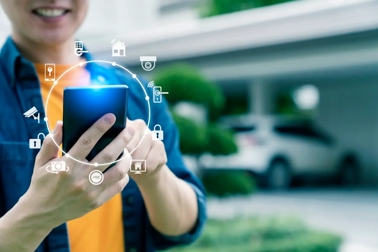 Man with hi-tech smart gadget IoT smart home technology, smart digital lifestyle car garage home automation control online by mobile app.