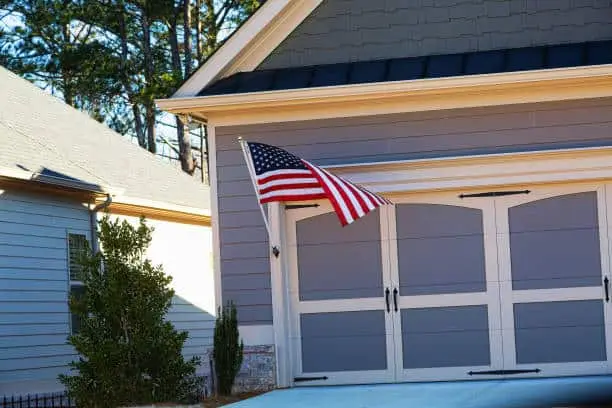 An American flag flying on the garage of a modern townhouse