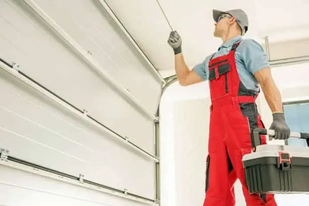 Modern Automatic Garage Doors Installation Performed by Professional Caucasian Installer. Residential Automation.