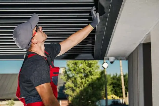 Garage Repair Technician repairing a overhead garage door.
