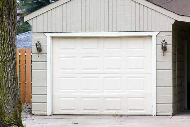 Single garage door on a grey house.