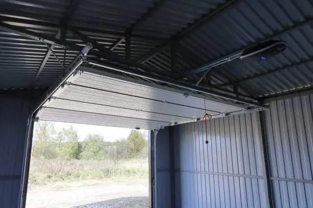 Open raised up automatic lift gate iron rural garage, hoist motor on top