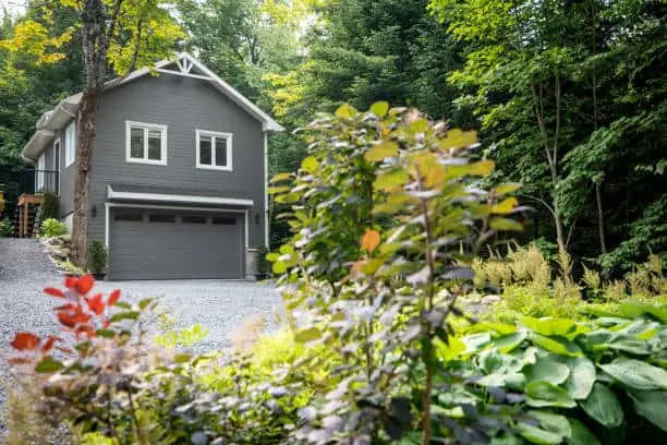 Luxurious gray and white two-story detached double garage located in Quebec, Canada during summer.