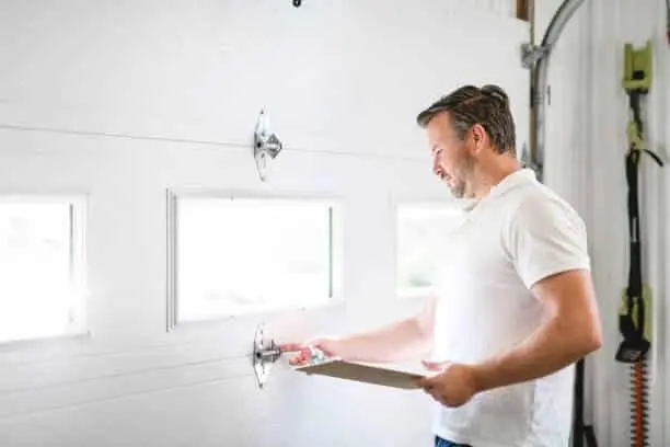A man inspecting or Fixing a garage door