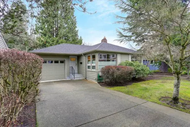 Small grey home exterior with a garage.