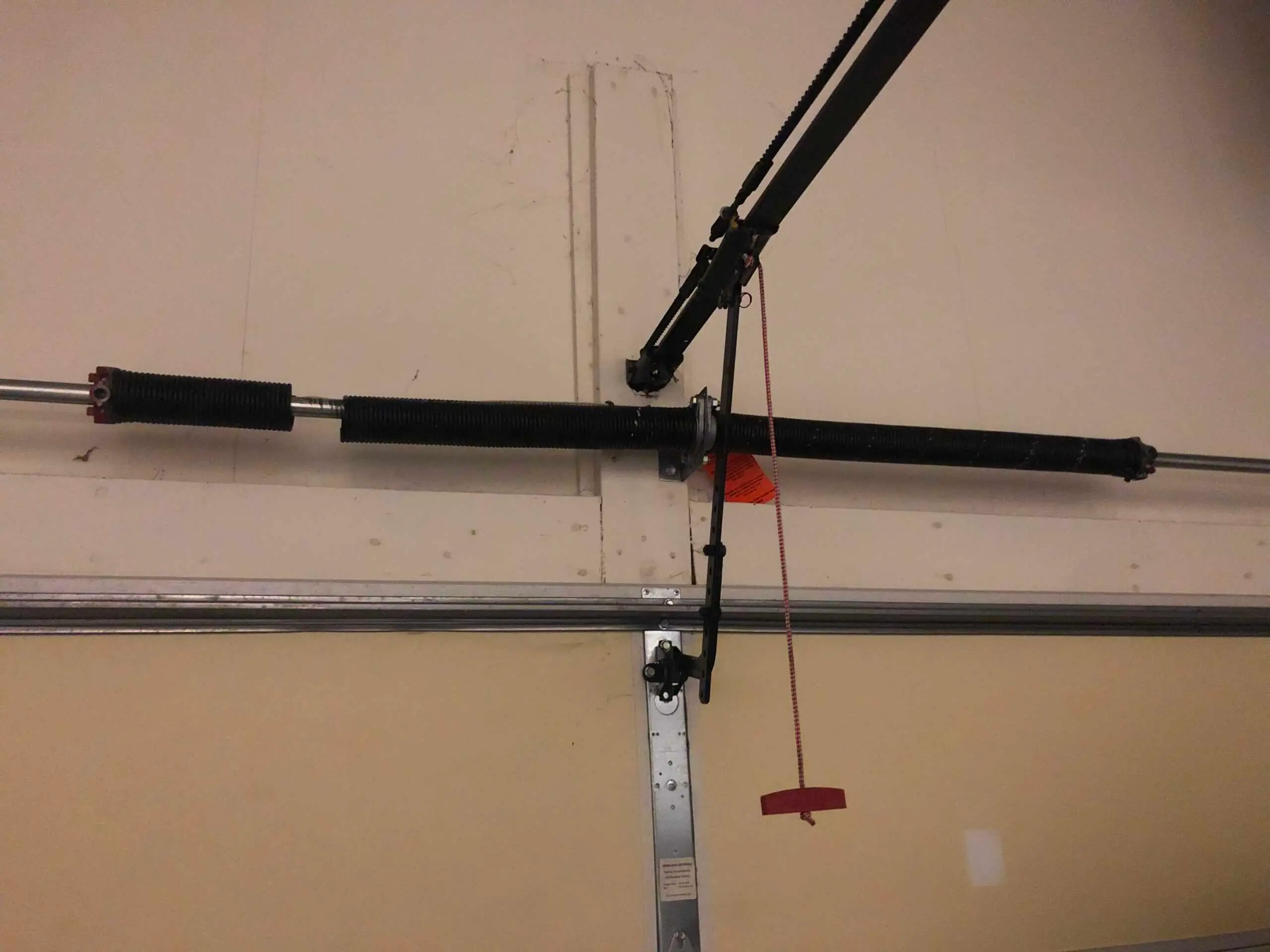 Broken garage door spring above a garage door.