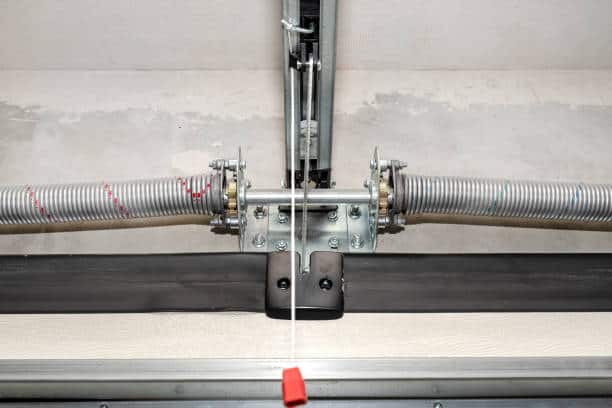 Springs tensioning the home garage door mechanism, view from the inside, visible rail with chain.