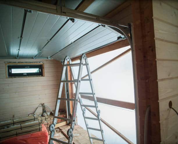 maintenance of a steel roller shutter door in a garage, indoor shot