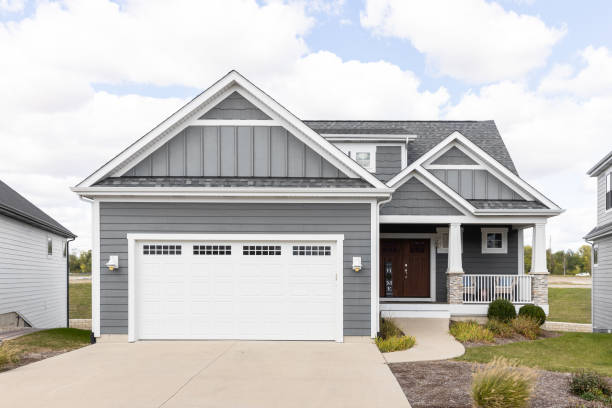 Grand Ledge, MI, A new, grey home with horizontal and vertical siding, white garage door, and covered front porch.