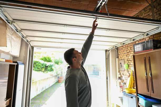 Man reaching for garage door opener. Madison Heights Garage Door Repair.