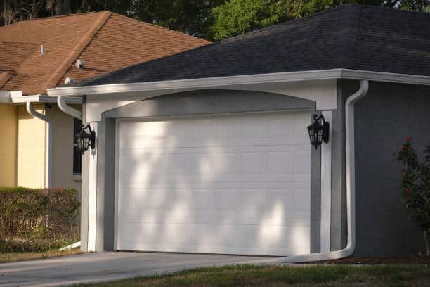 Wide garage double door and concrete driveway of new modern american house.