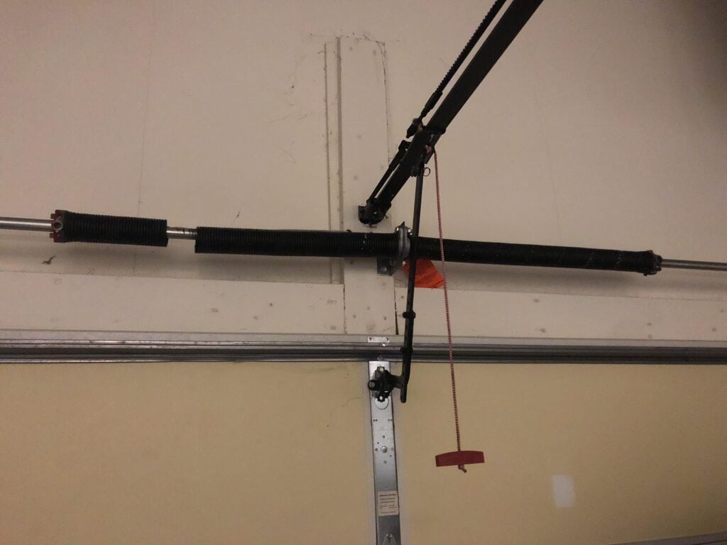 Broken garage door spring above a garage door.