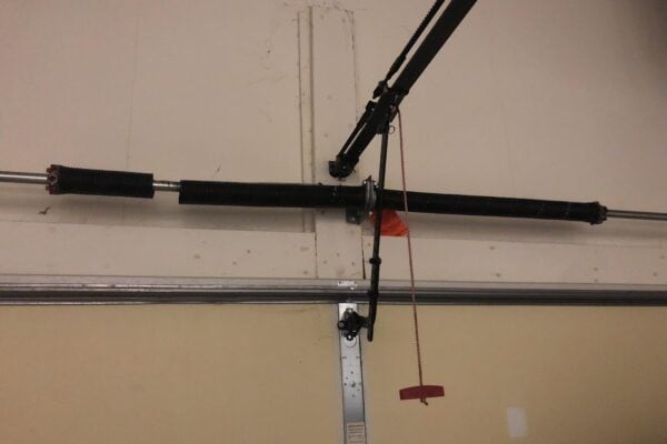 Broken garage door spring above a garage door.