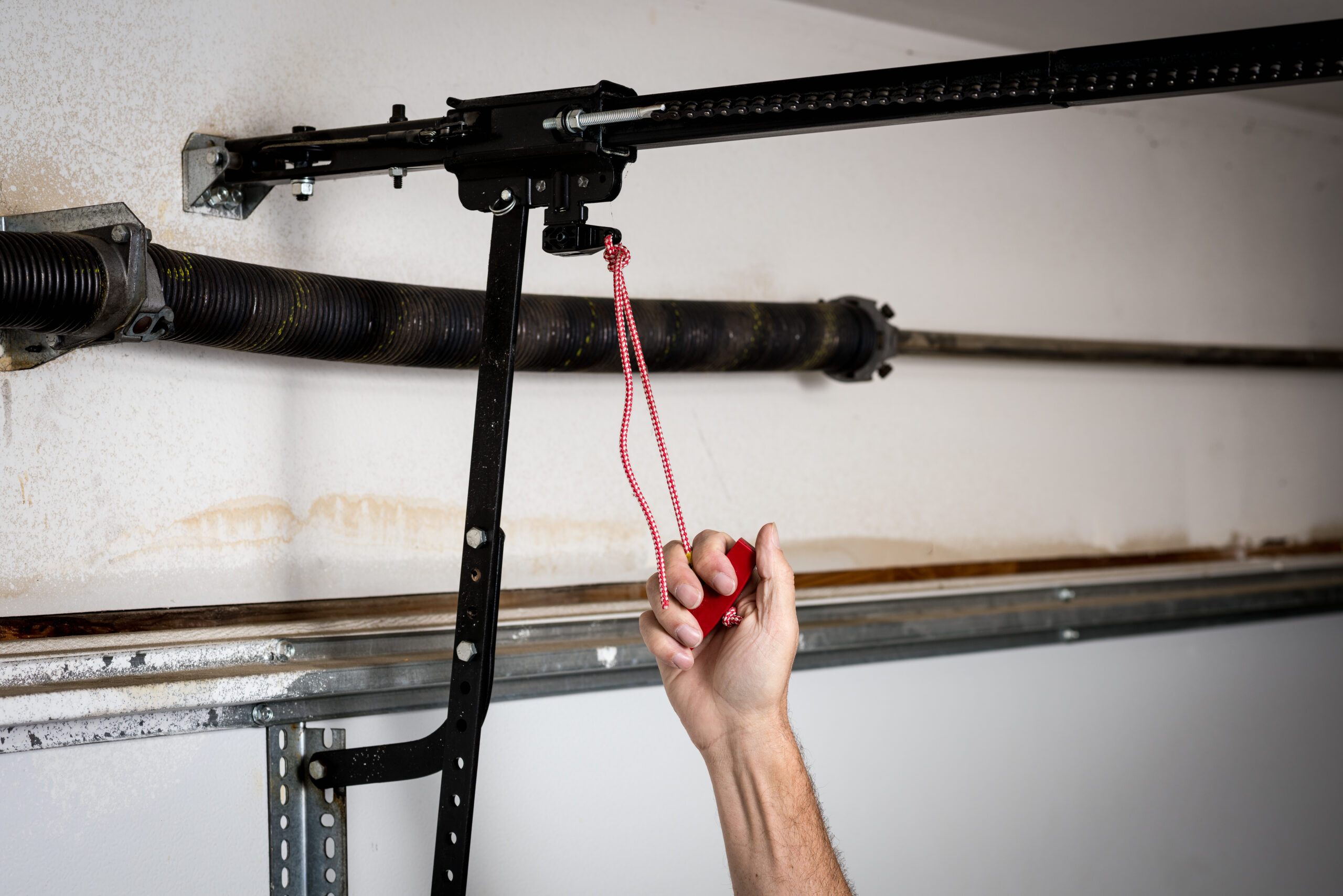Close up of a hand pulling the release handle on a garage door.