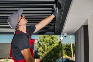 Garage Repair Technician repairing a overhead garage door.