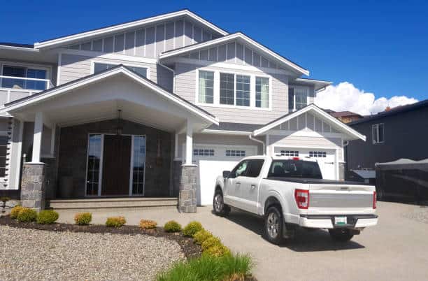 Modern white house with a white pickup truck in the driveway.