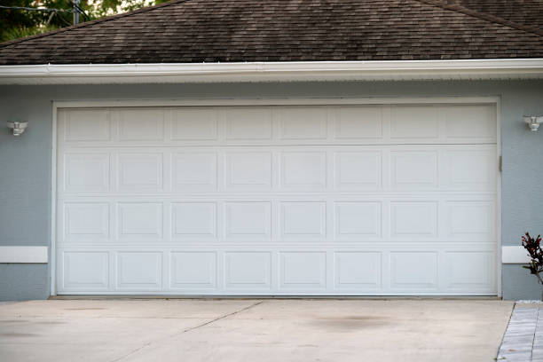 Wide garage double door and concrete driveway of new modern American house.