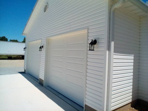 Two white single garage doors on a white house.