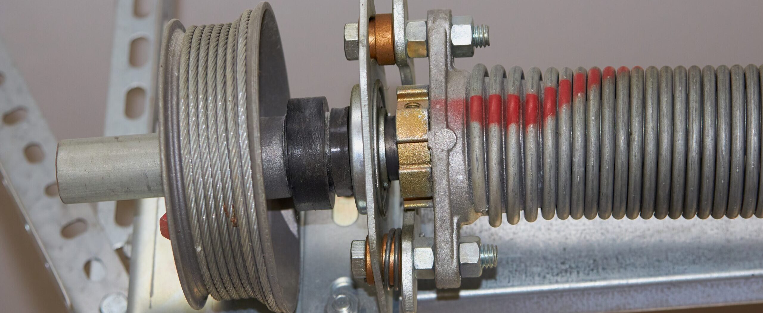 Close up of a garage door spring and cable drum