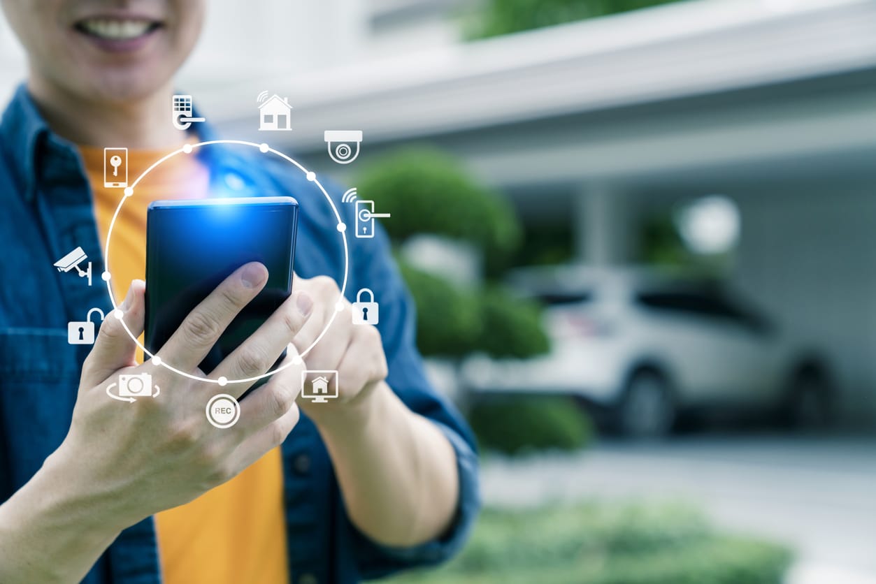 Man with hi-tech smart gadget IoT smart home technology, smart digital lifestyle car garage home automation control online by mobile app.